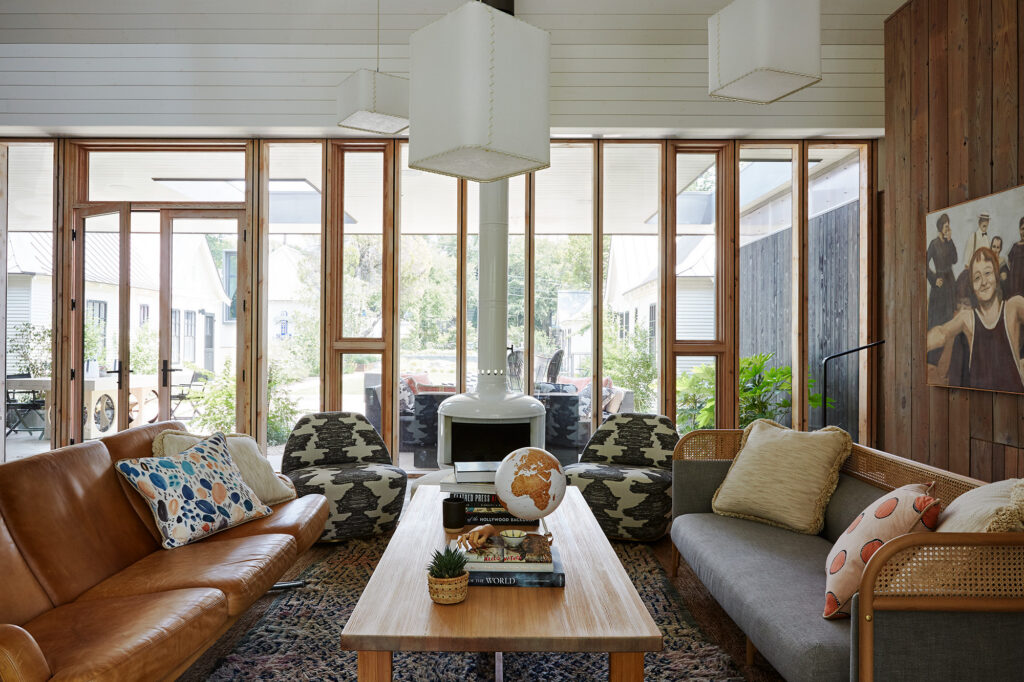 Character-rich living room with floor-to-ceiling wood-framed windows and eclectic furnishings designed by Amity Worrel & Co. — aging-in-place interior design in Austin, TX