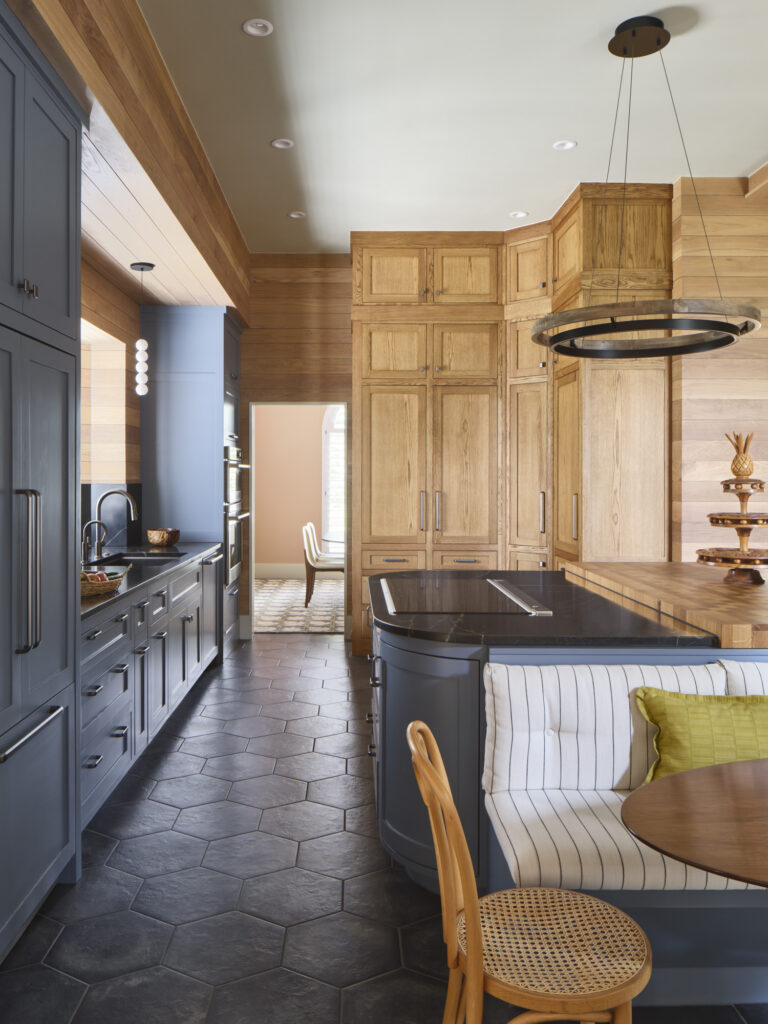 Detailed kitchen with blue-gray cabinetry, natural wood pantry, hexagonal tile floors, and built-in banquette designed by Amity Worrel & Co. — aging-in-place kitchen remodeling in Austin, TX