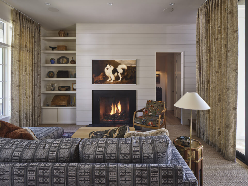 Warm living room with shiplap fireplace wall, built-in shelving, and layered textiles designed by Amity Worrel & Co. — aging-in-place interior design in Austin, TX