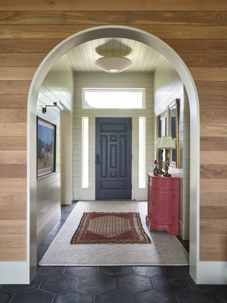 Welcoming home entryway with arched doorway, hexagonal tile floors, and abundant natural light designed by Amity Worrel & Co. — aging-in-place entryway design in Austin, TX