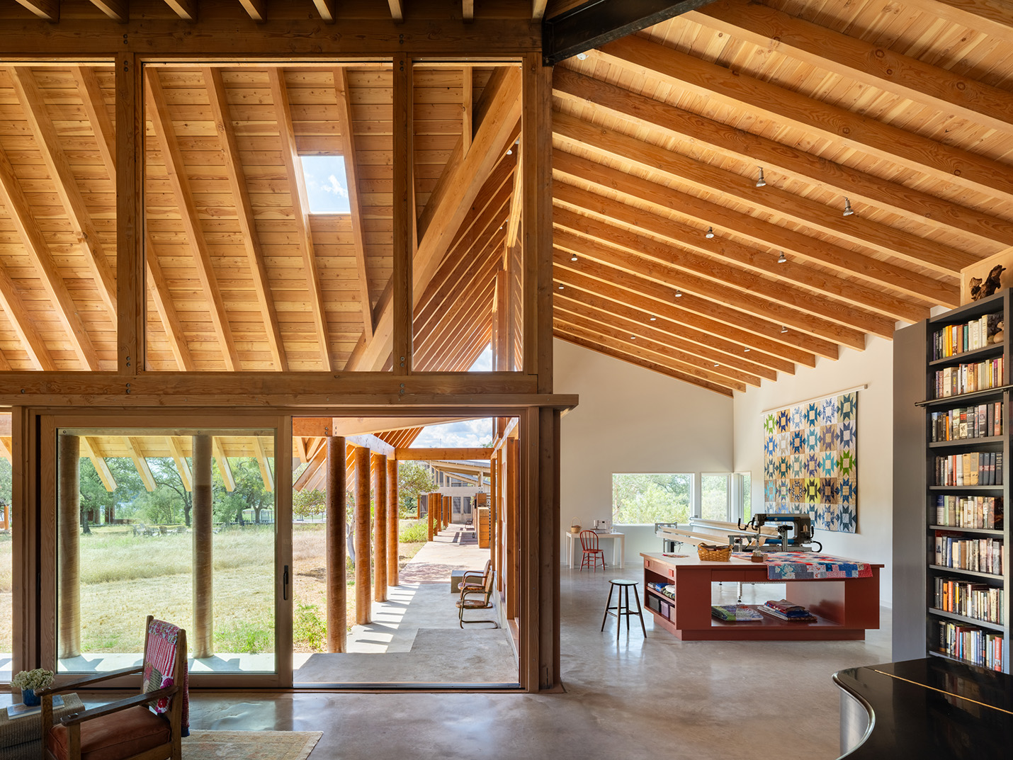 Open-plan interior with exposed timber beam ceiling and seamless indoor-outdoor access by Texas Construction Company — aging-in-place home remodeling in Austin, TX
